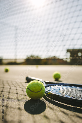 Fototapeta Naklejka Na Ścianę i Meble -  Close up of a tennis racket and balls lying on a court