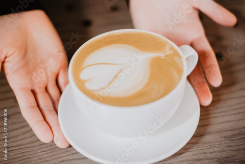 hand holding cup of coffee on black background