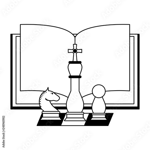 Book open with chess pieces in black and white