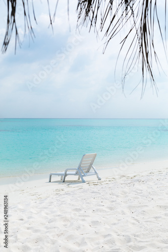 Fototapeta Naklejka Na Ścianę i Meble -  Sun chair on sandy beach at tropical vacation,