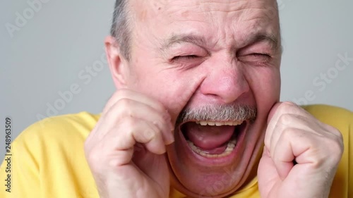 Senior scared man covering his face with hands as he saw a real monster.