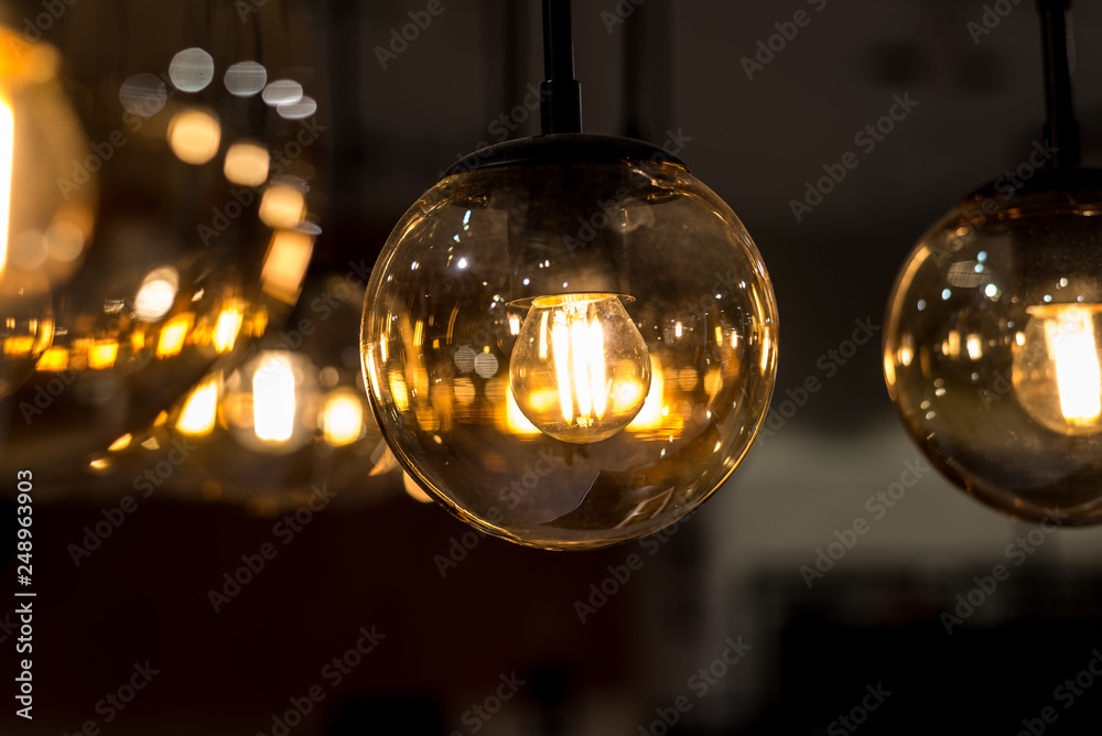 many burning incandescent bulbs hanging on the ceiling many burning incandescent bulbs hanging on the ceiling