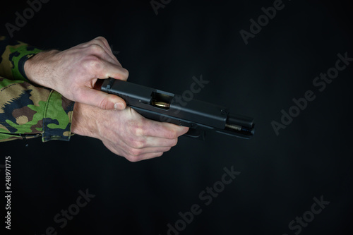 Soldier is loading the gun in his hands