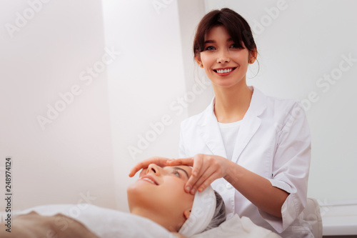 Positive happy female cosmetologist enjoying her job