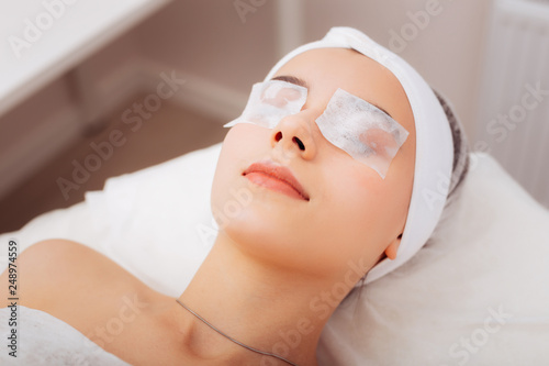 Positive joyful woman enjoying the beauty procedure photo