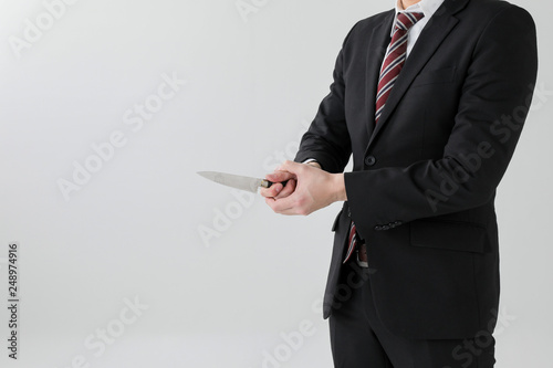 Foto ナイフを持ったスーツ姿の上半身の男性