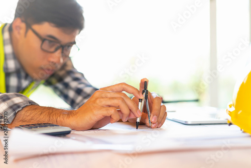 Architect working on blueprint.engineer inspective in workplace - architectural project, blueprints,ruler,calculator,laptop and divider compass. photo