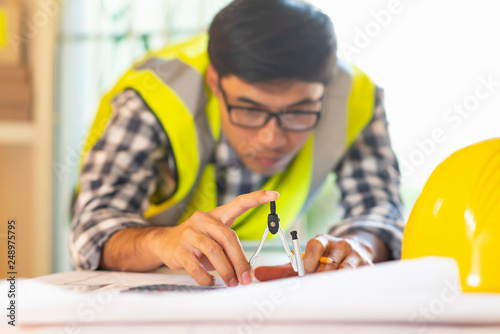 Architect working on blueprint.engineer inspective in workplace - architectural project, blueprints,ruler,calculator,laptop and divider compass. photo