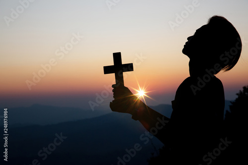 Faith of christian concept: Spiritual prayer hands over sun shine with blurred beautiful sunset background