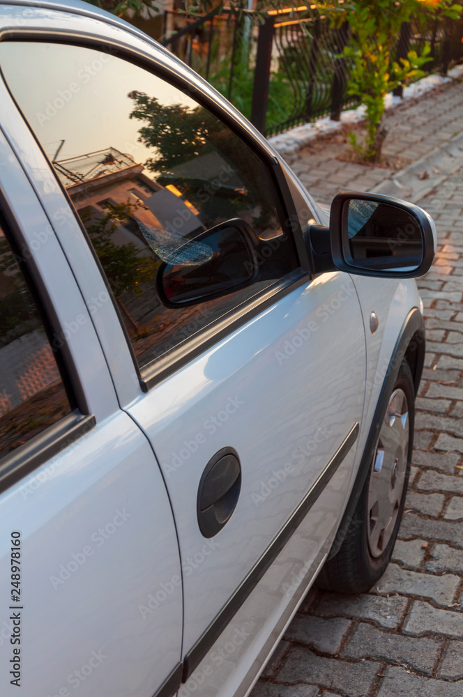 Fototapeta premium Close up of car mirror with reflection of behind the car.