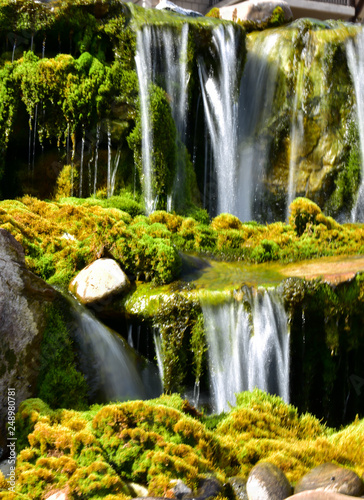 waterfall splashing on mossy rocks below