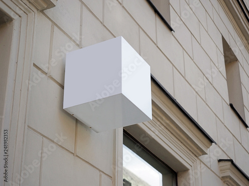 Signboard side view of empty white mock up cubic, squared, box,  signage with old city wall background display exterior.