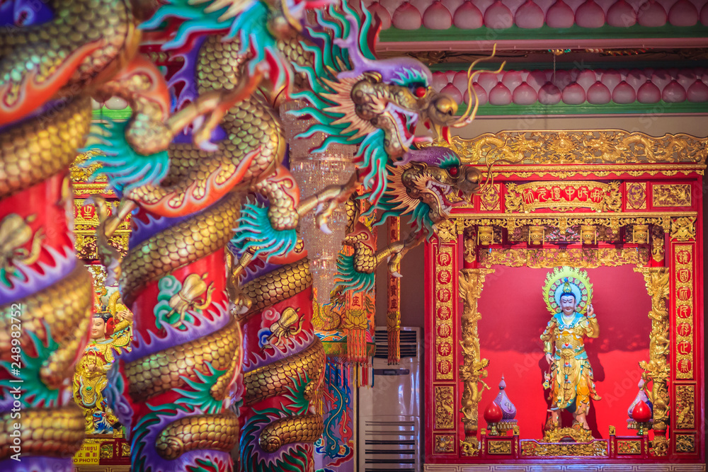Colorful dragons and statue of Nezha, the protective deity in Chinese folk religion at Chinese public temple.