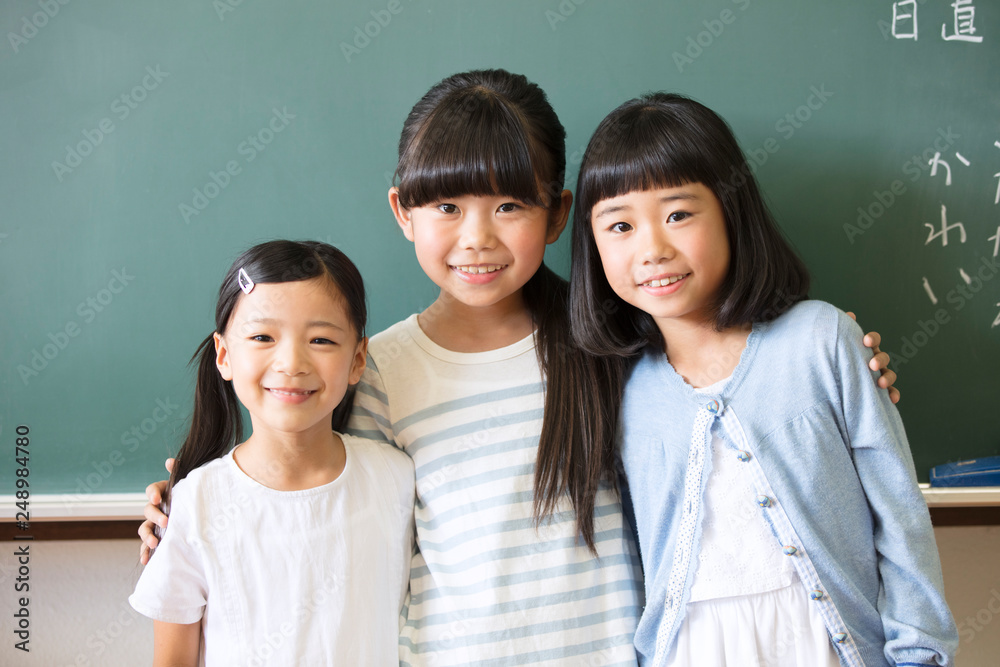 黒板の前で肩を組んで笑う女の子3人 Stock Photo Adobe Stock