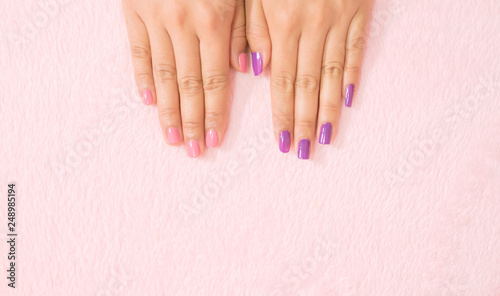 Close up female hand nails color on pink background.