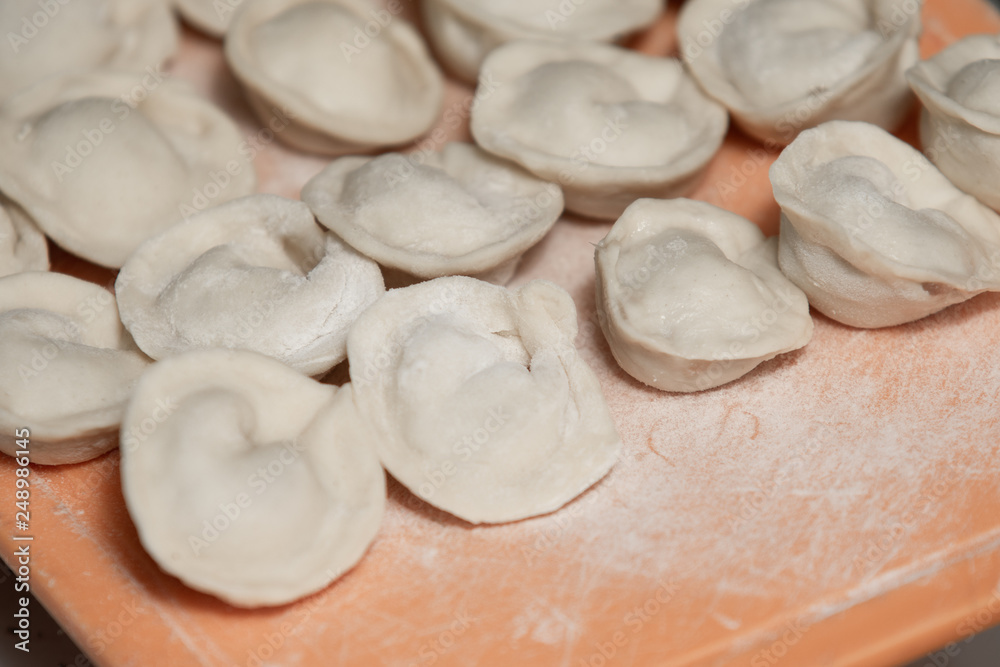 Homemade dumplings from dough and minced meat, preparation  ravioli, with minced meat close up.