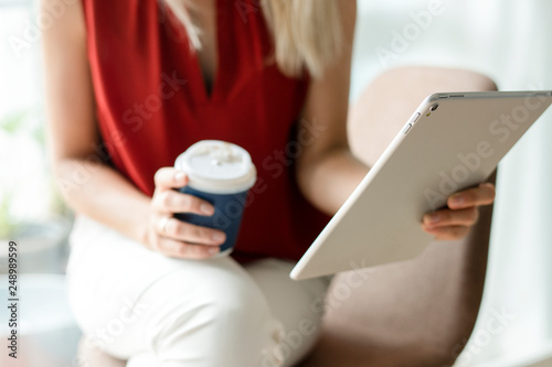 Fényképezés Businesswoman reading thew news from a digital tablet