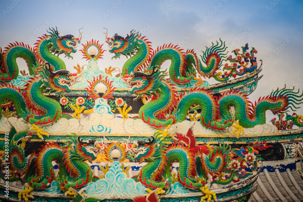 Colorful chinese dragon statues on roof in Chinese temple. Chinese dragons on the roof top of shrine. Colorful chinese dragon statues on roof in Chinese temple. Chinese dragons on the roof top of shrine.