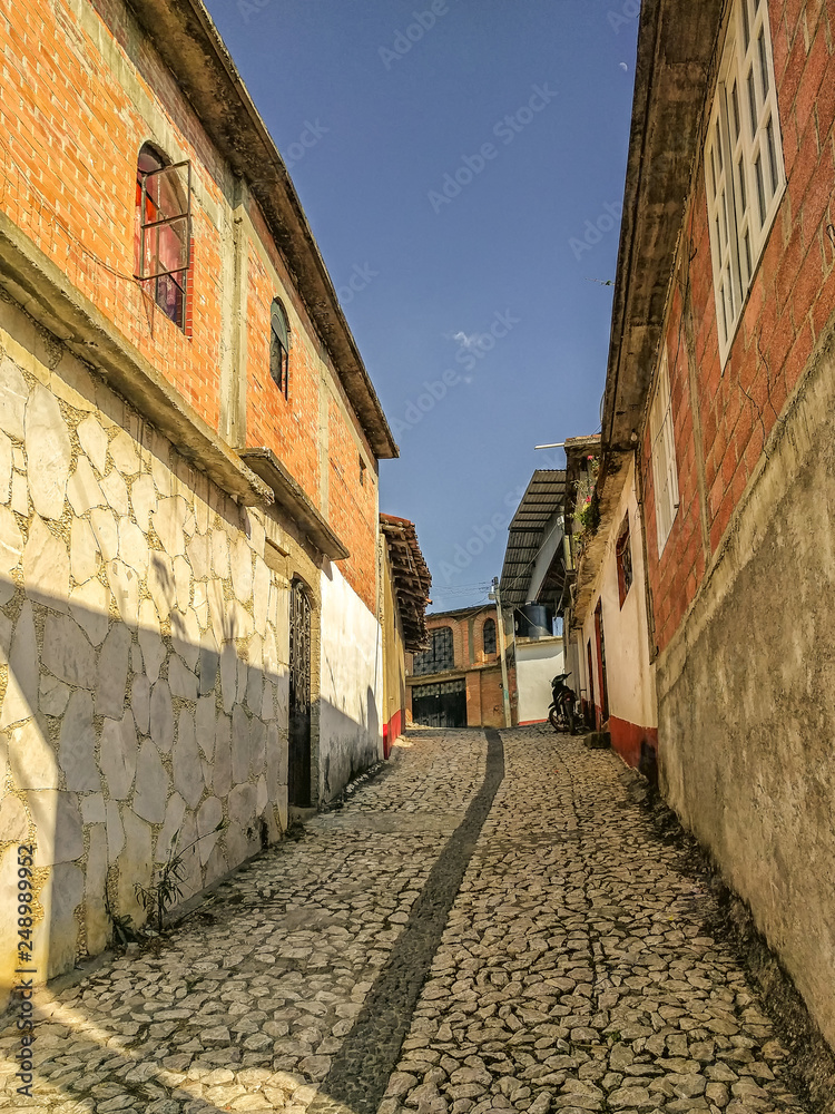 An uphill view of a neighborhood street that is paved with marble stones in Ixcateopan. Main streets in Guerrero. Travel in historic Mexico. An uphill view of a neighborhood street that is paved with marble stones in Ixcateopan. Main streets in Guerrero. Travel in historic Mexico.