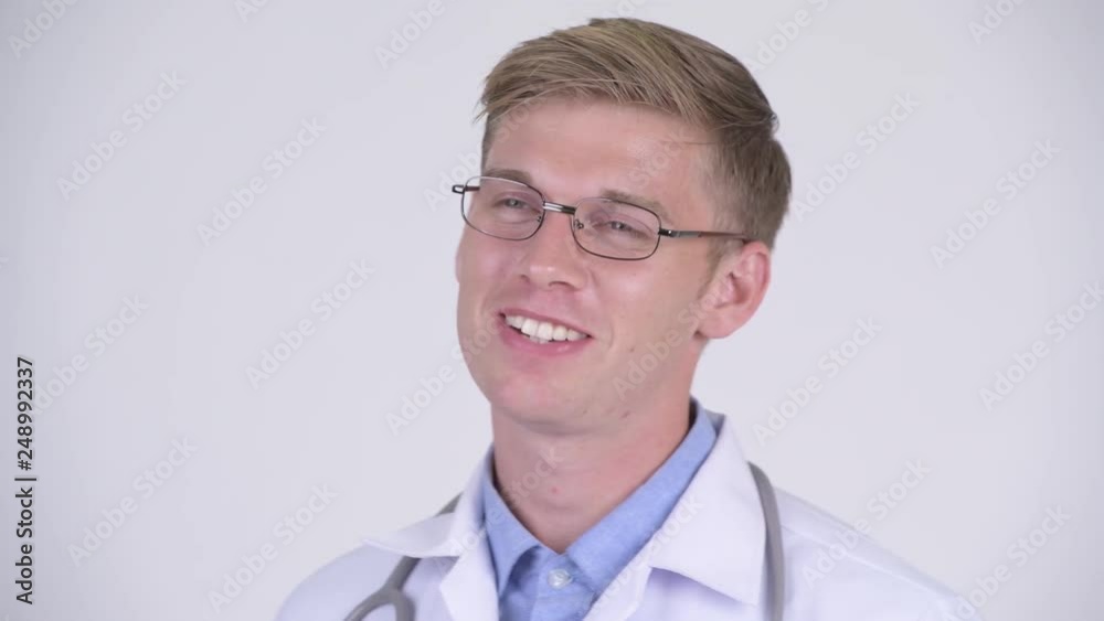Face of happy young handsome man doctor with eyeglasses being interviewed Face of happy young handsome man doctor with eyeglasses being interviewed