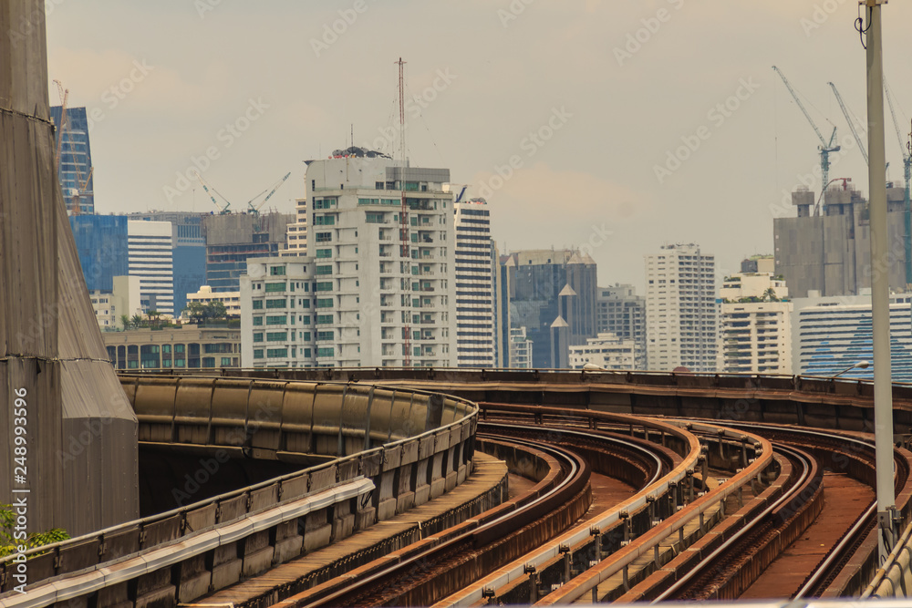 Curve of elevated railway on the forest of building construction in the city background. Capital city, metropolis and development concept.