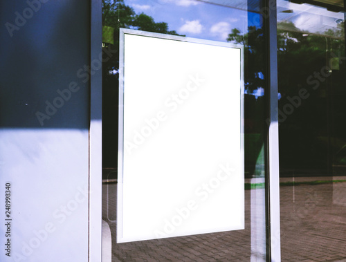 Empty white poster, photo frame, behind a window