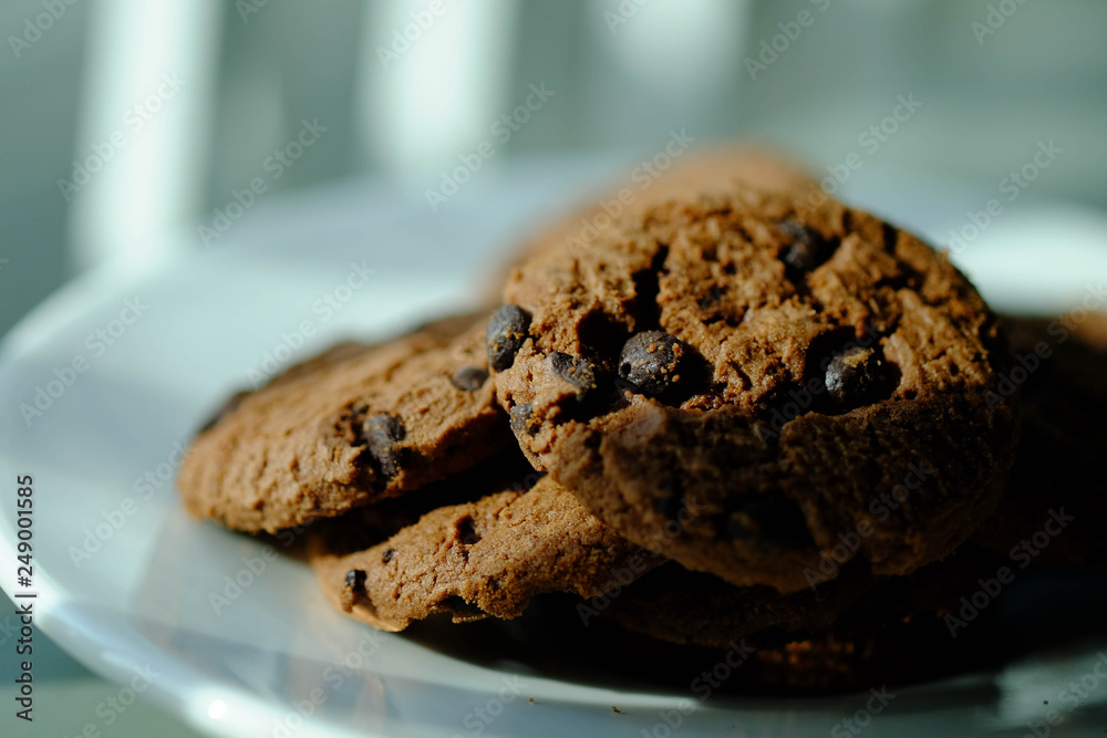 Fototapeta premium Close up Chocolate cookies in white dish and Light from the window
