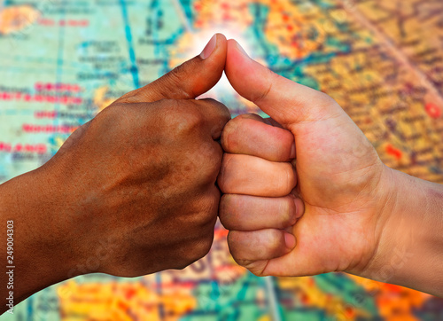 multiracial hands together African American and Caucasian touching thumbs as team in promise sign of mutual trust representing world diversity respect photo