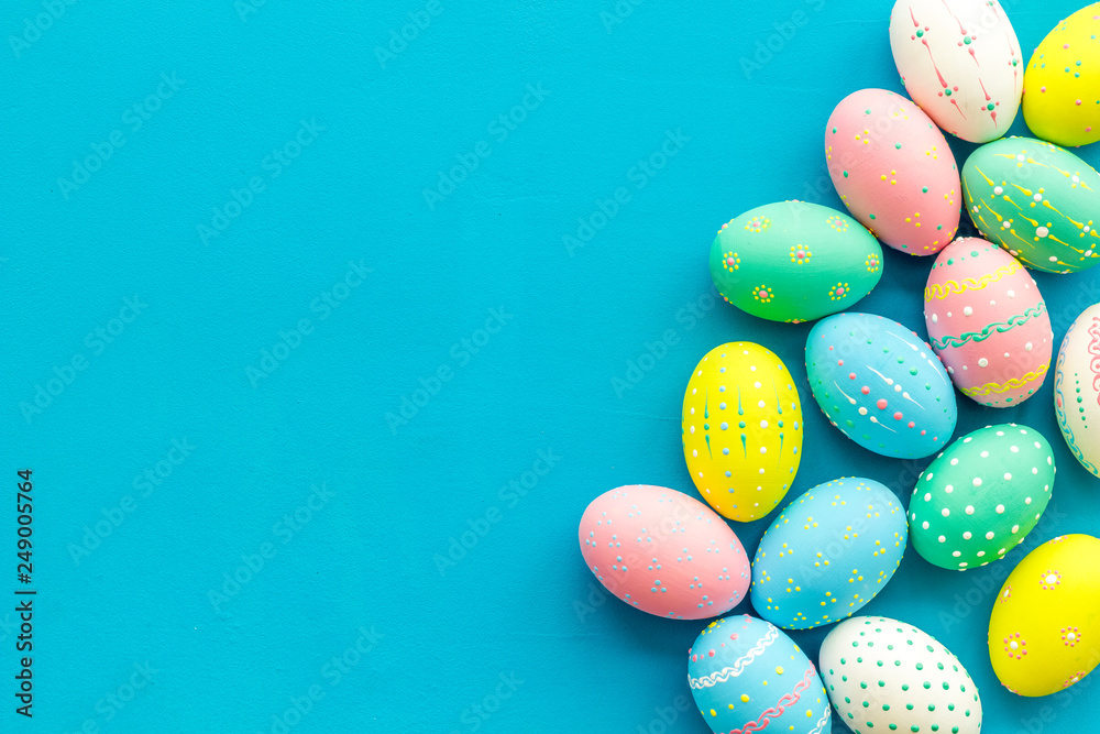 Easter composition. Decorated pastel Easter eggs on blue background top view copy space