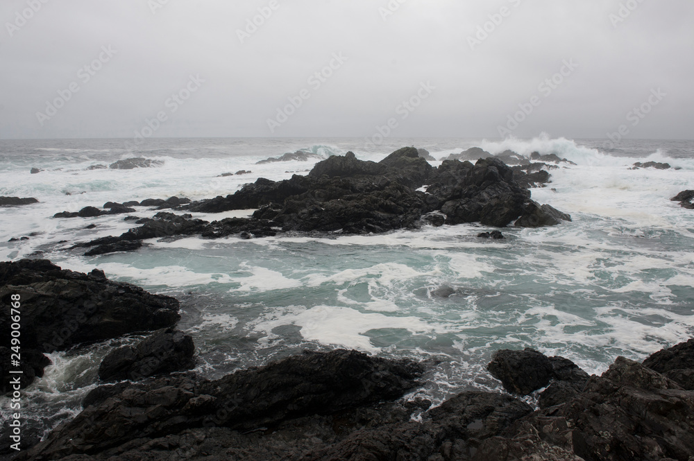 Waves crashing on rocks along a shoreline Waves crashing on rocks along a shoreline