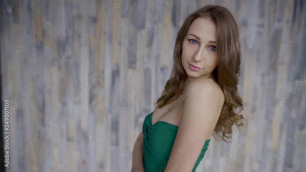 Beautiful young girl in green dress poses indoor.