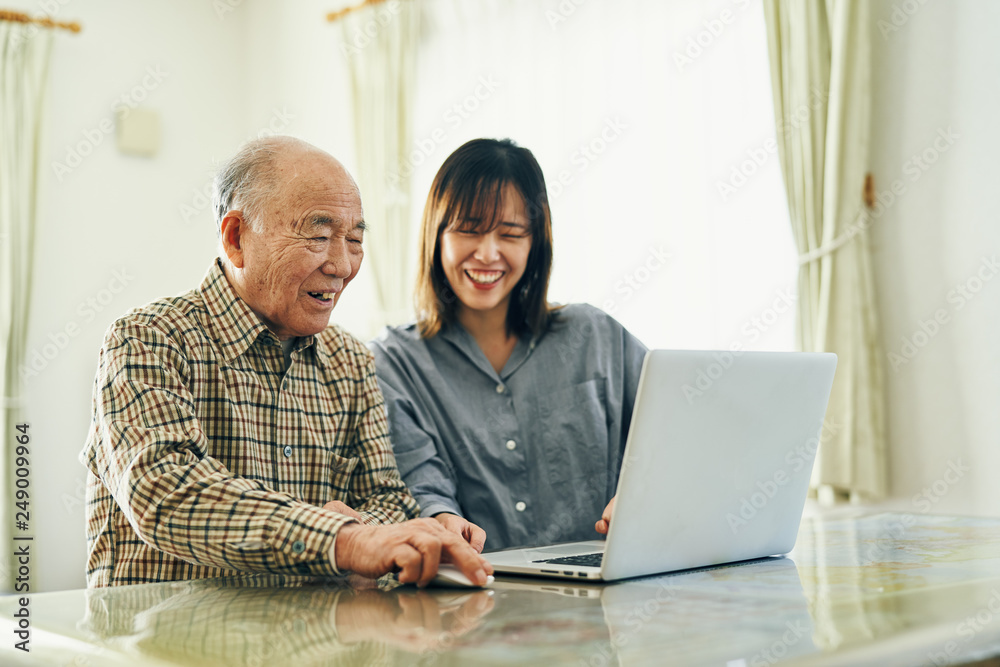 Grandfather and granddaughter using laptop at home Grandfather and granddaughter using laptop at home