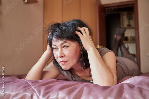 Nice middle-aged woman in the bed room. Lady at home
