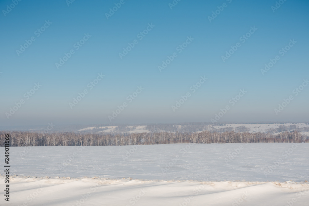 Snowy field Winter landscape. Frosty day. Russian winter nature.
