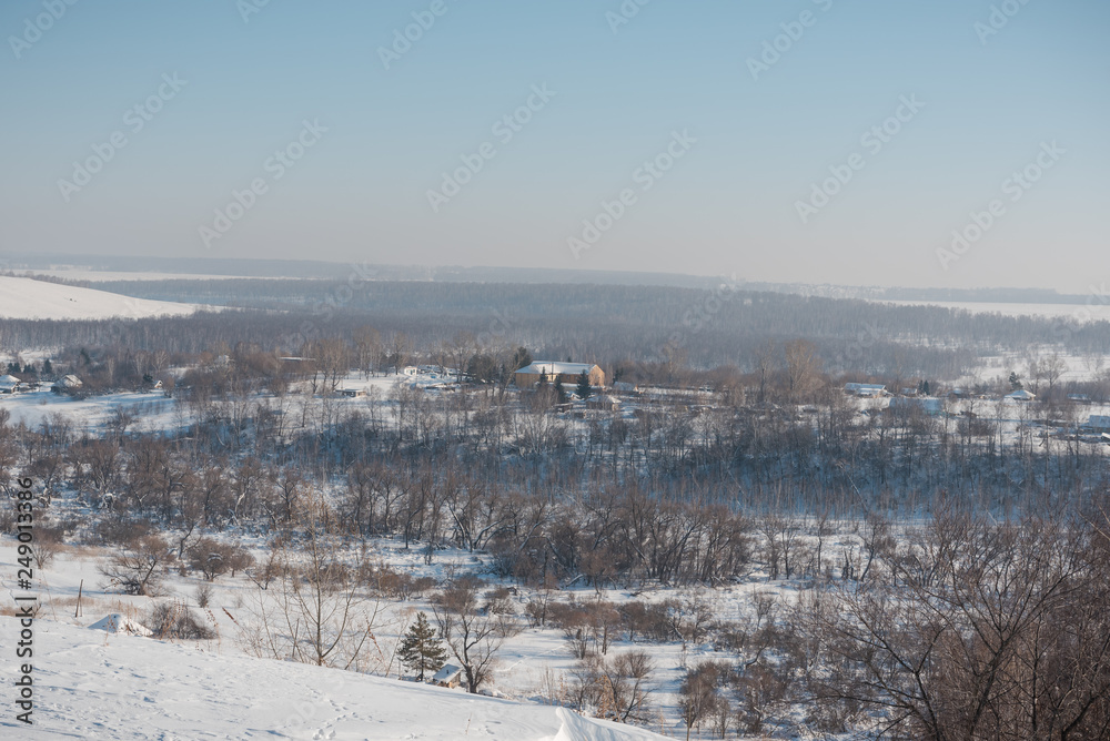 Winter view of the village from above. Houses in the snow. Countryside under the snow.