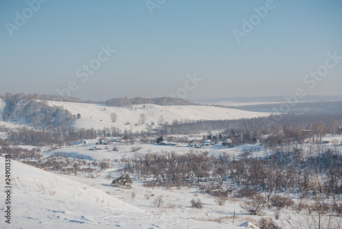 Winter view of the village from above. Houses in the snow. Countryside under the snow. © Sergey_Siberia88