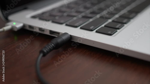 Close up of plugging in a headphone jack and usb cord in photo