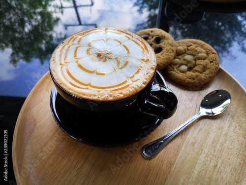 Coffee and cookies placed on a beautiful wooden plate photo