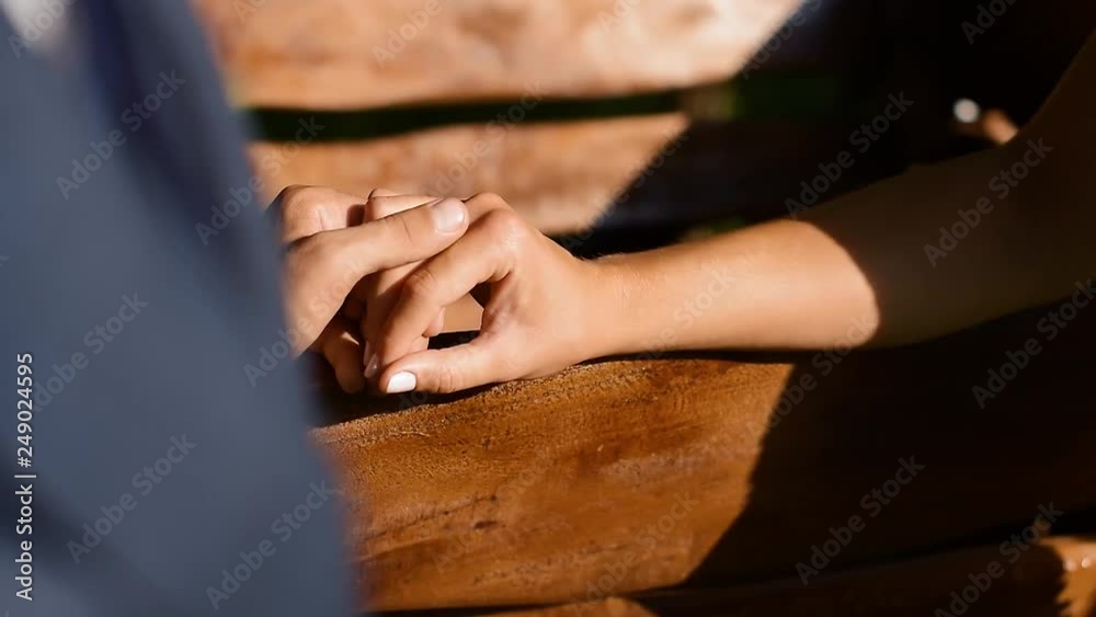Man and woman holding hands on wooden bench Man and woman holding hands on wooden bench
