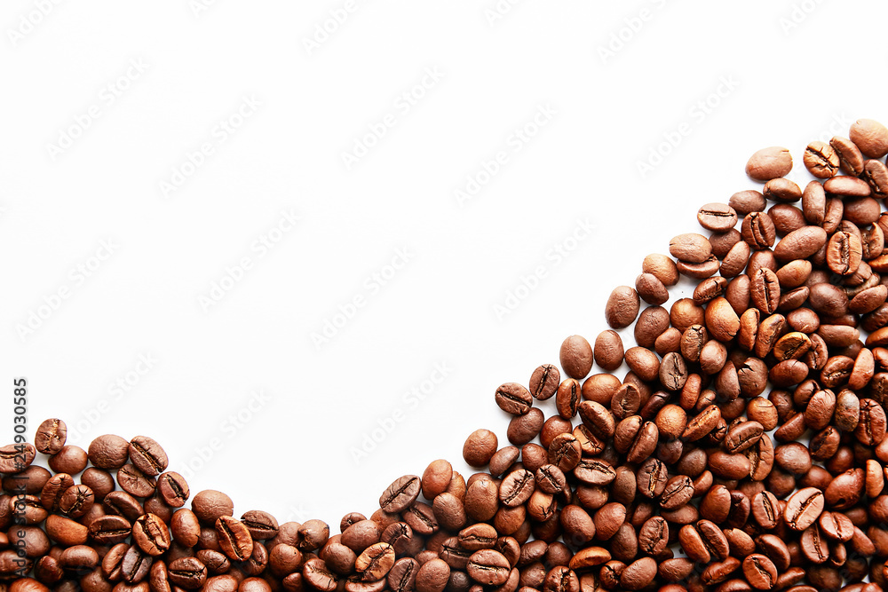 Roasted brown coffee beans scattered on white table with a lot copy space for text. Flat lay composition. Close up, top view, background. Roasted brown coffee beans scattered on white table with a lot copy space for text. Flat lay composition. Close up, top view, background.