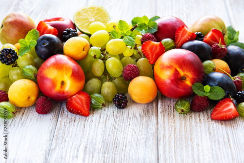 Fresh summer fruits and berries on a white wooden table