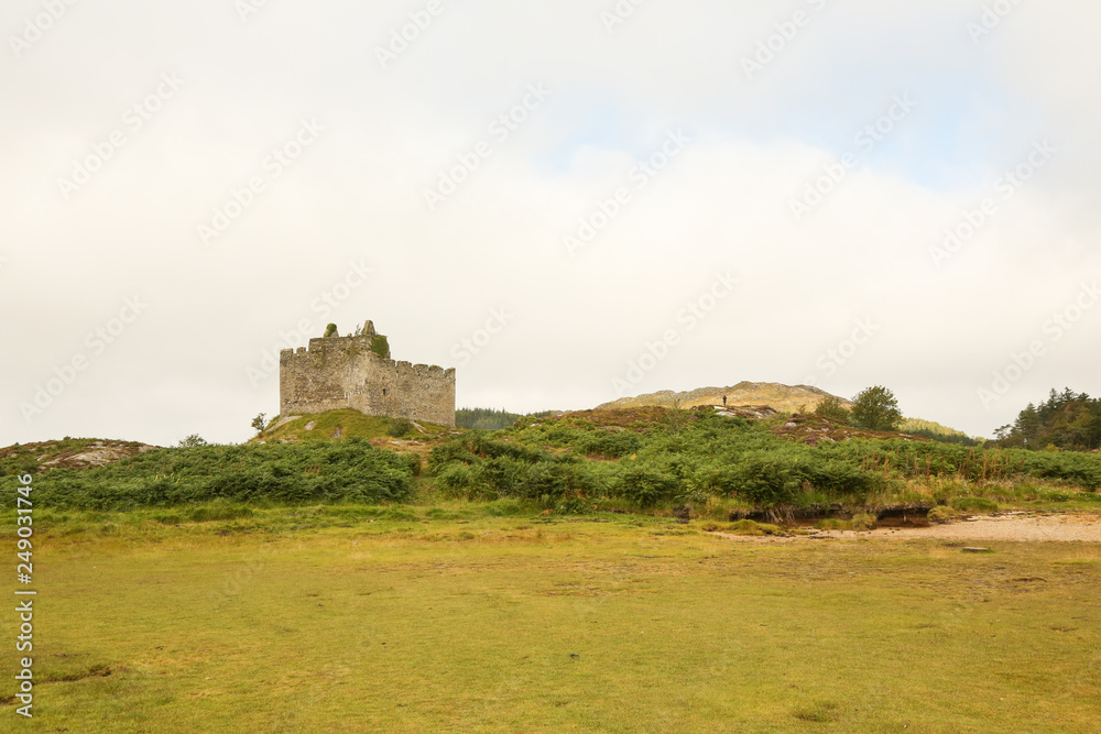 A landscape view of the ruins of Tioram Castle on Loch Moidart south of Mallaig, Scotland, UK.	