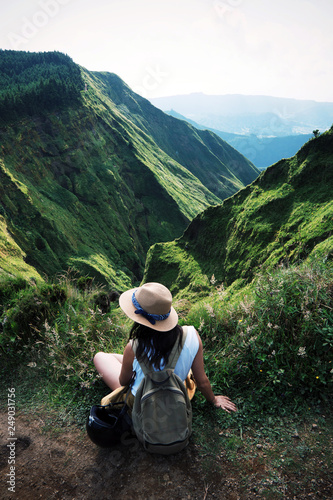 woman traveler holding hat and looking at amazing mountains and forest, wanderlust travel concept, space for text, atmospheric epic moment, azores, ponta delgada, sao miguel, stills wallpaper