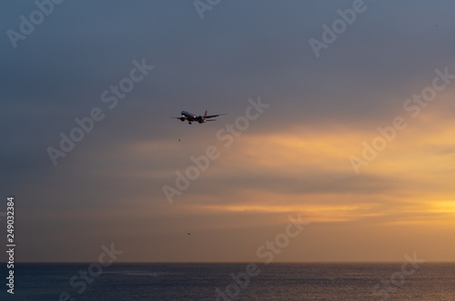 A airplane flying in the sky at sunset © nkeskin