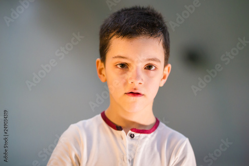 A little boy standing on the football field and looking directly at the camera after the game  portrait