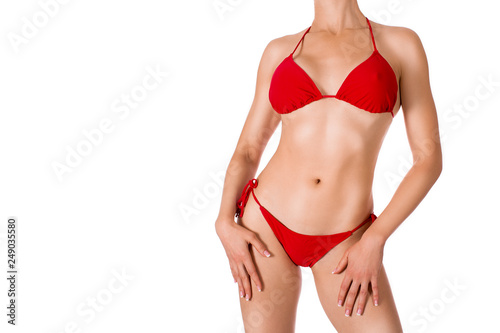 Female cropped sexy tanned fit body in red classic bikini, isolated on white