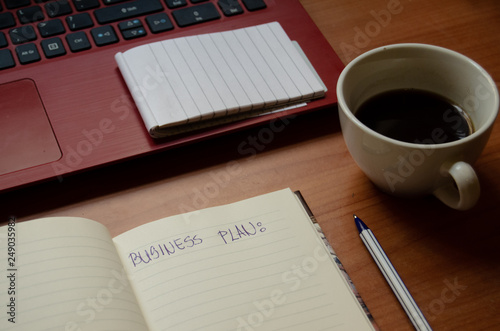 home office desk, red laptop, coffee, notebooks, diary, pen
