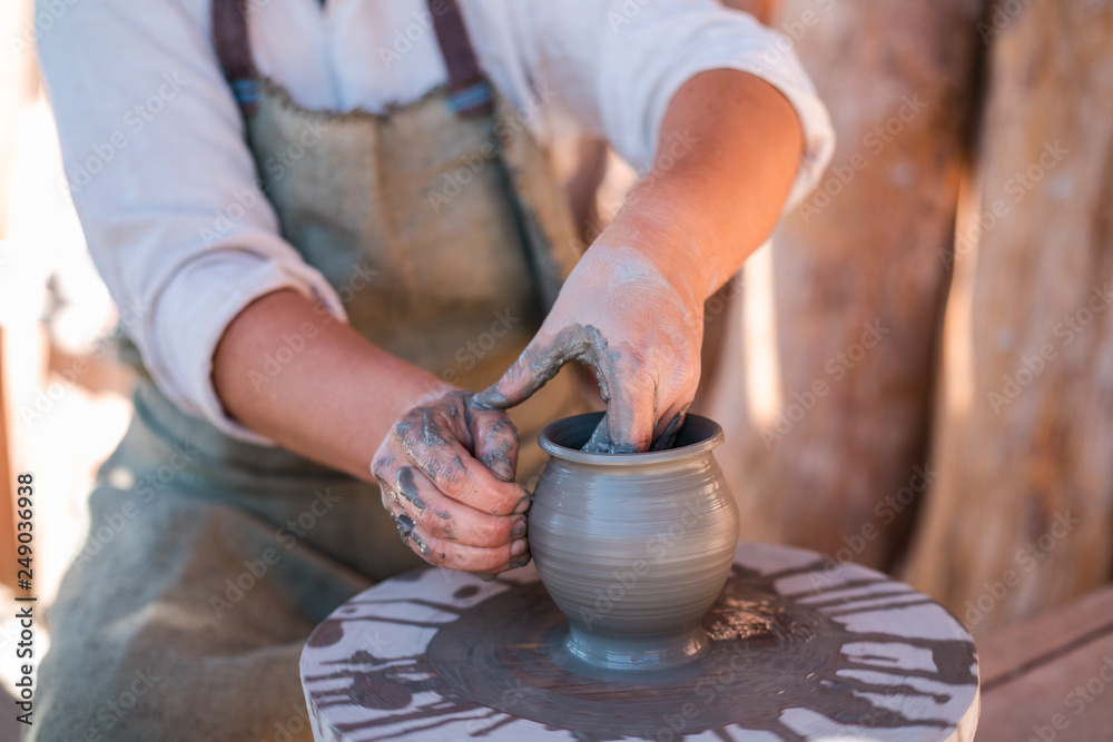 Potter is creating earthenware on potter's wheel.