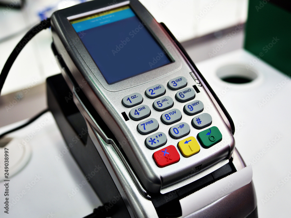 Close up of machine to pay with credit card swipe through terminal for payment in a shopping store, Isometric POS terminal confirms the payment by debit credit card. Close up of machine to pay with credit card swipe through terminal for payment in a shopping store, Isometric POS terminal confirms the payment by debit credit card.