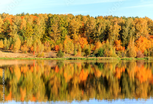 Autumn, autumn trees, yellow, red and green reflected in the water, morning